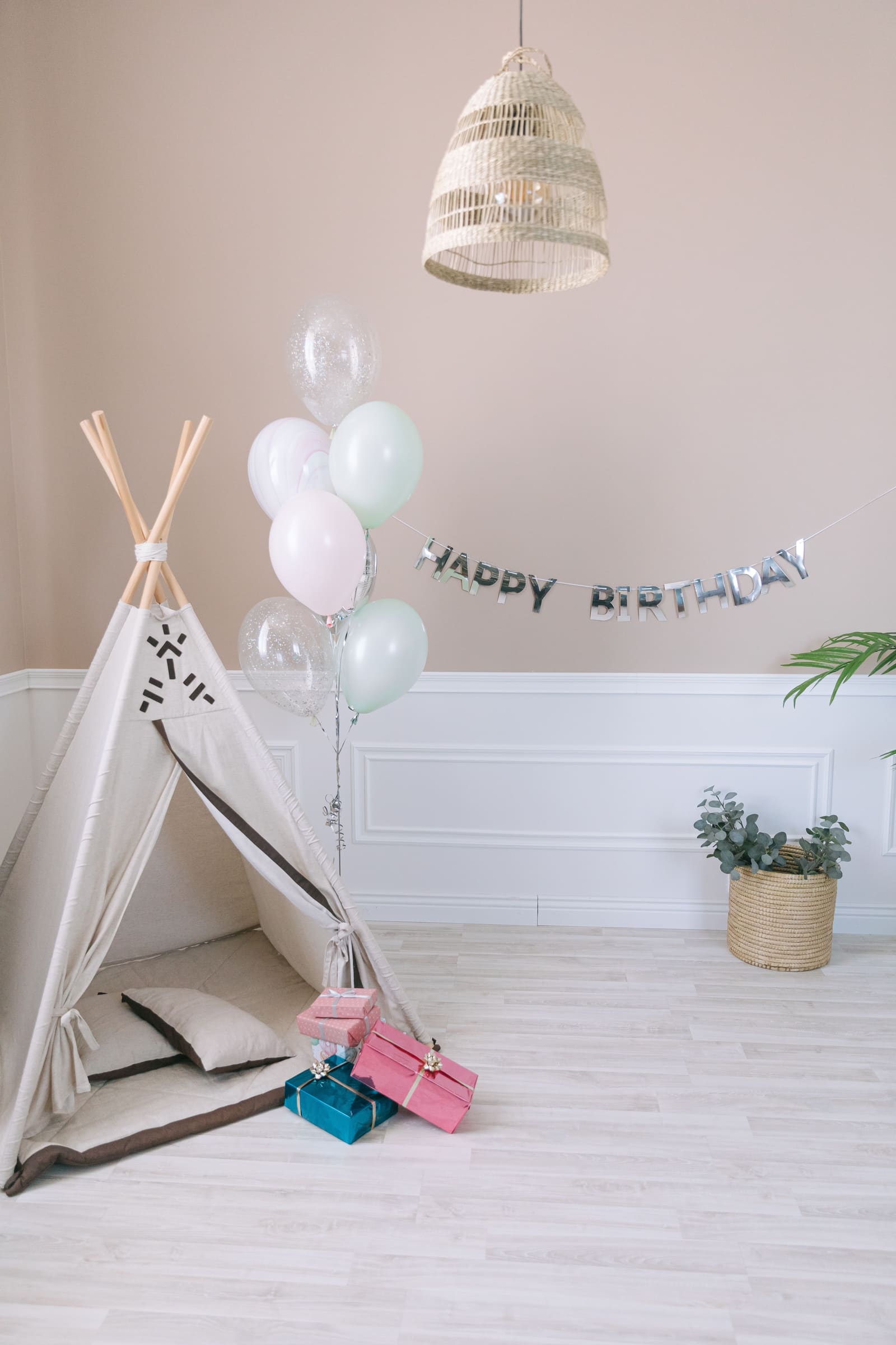 Wrapped birthday presents and colourful balloons arranged beside a play teepee, ideal for birthday gifts for 9 year olds UK