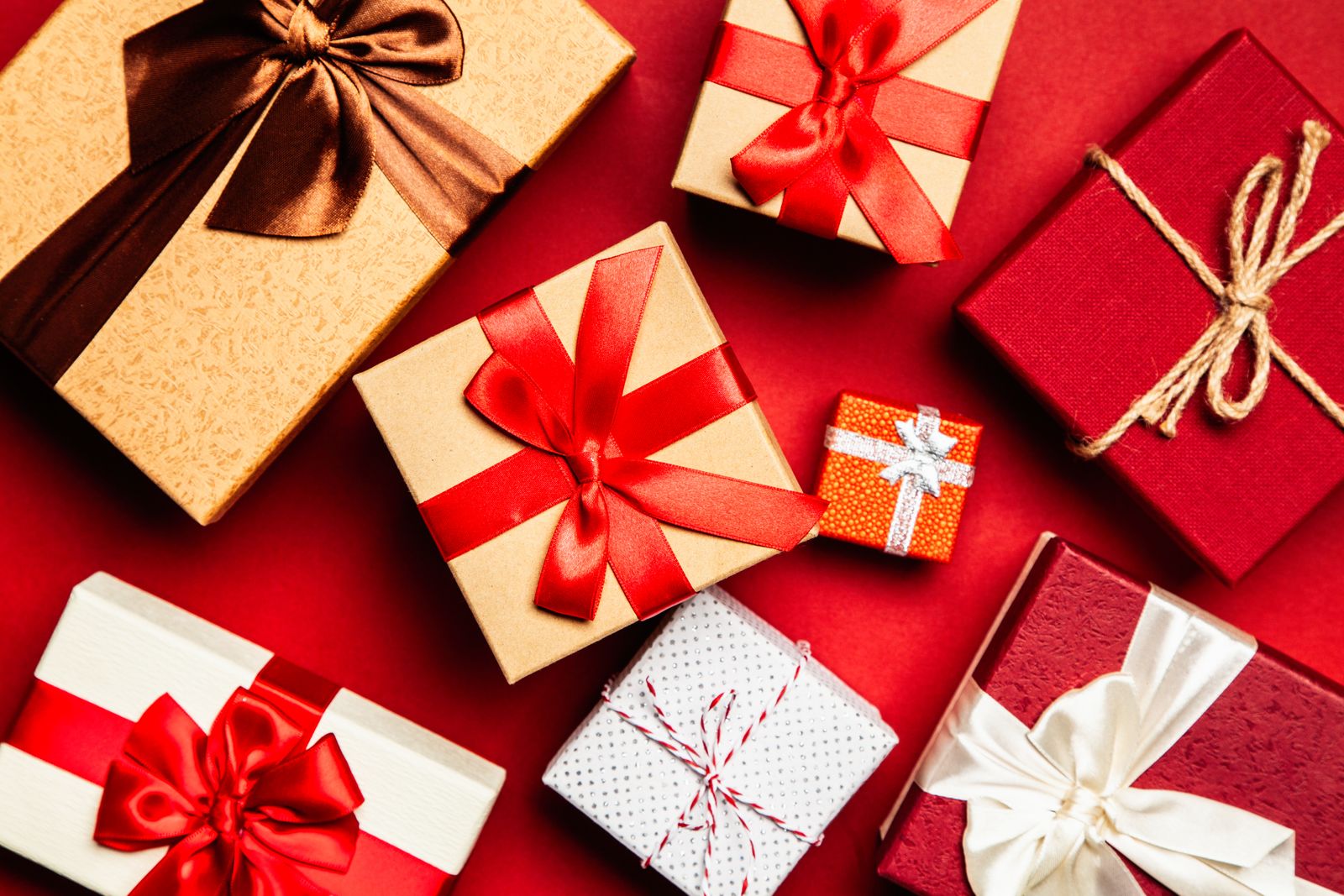 Colourful wrapped presents with ribbons on a red background