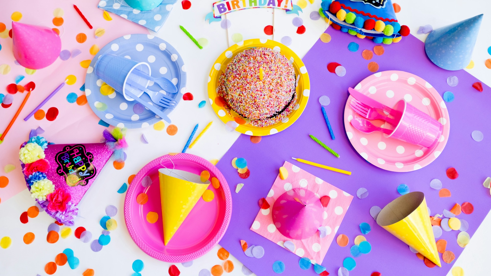 Party hats, polka-dot plates and confetti on a table &mdash; first birthday party ideas