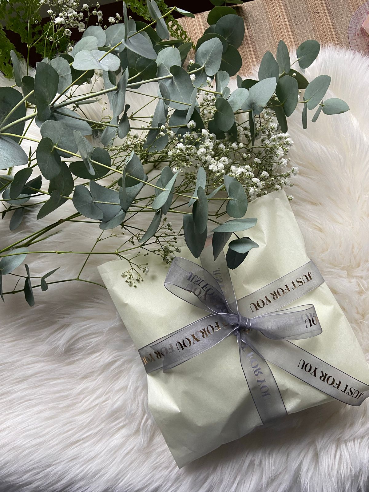 Beautifully wrapped gift with eucalyptus leaves and soft florals, ideal for a naming ceremony gift in the UK