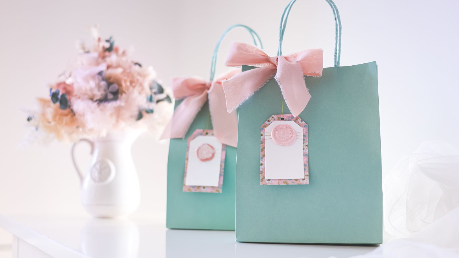 Elegant gift bags with pink bows on a white surface — personalised gifts for girls UK