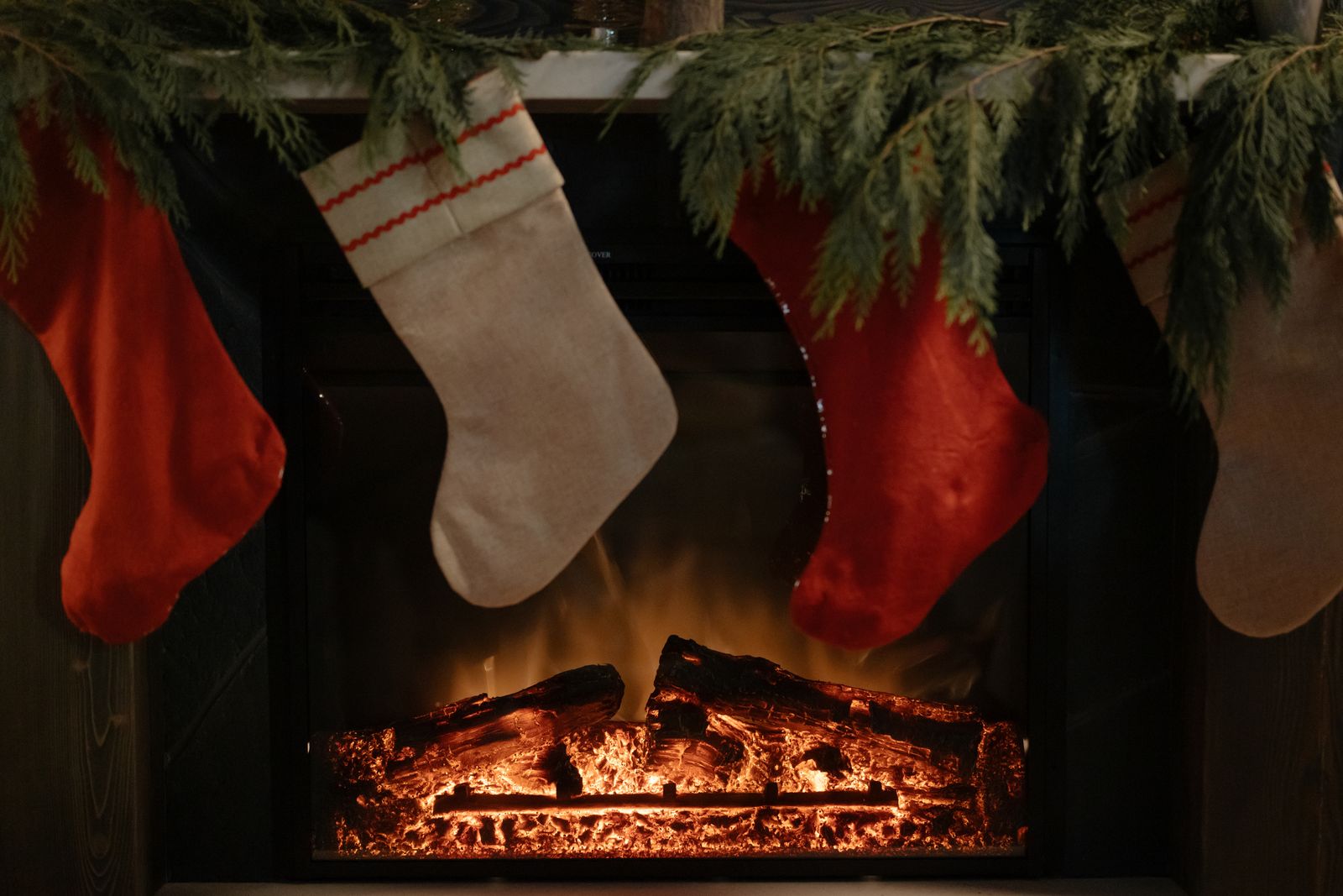 Christmas stockings hanging above a lit fire, stocking filler ideas for kids