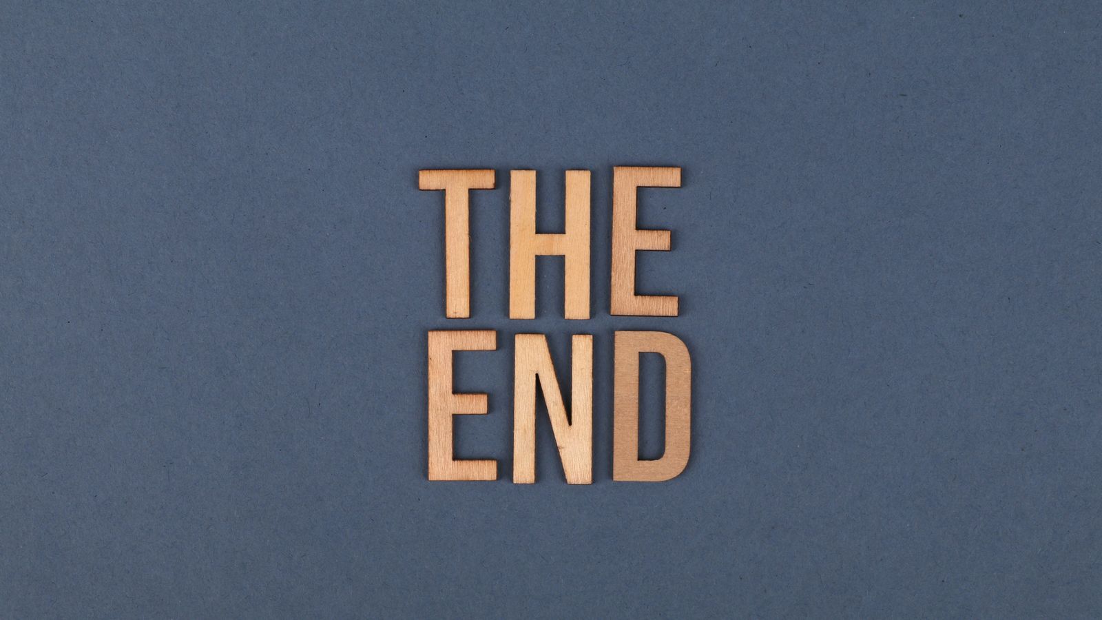 Wooden letter tiles spelling THE END on a blue surface — why hearing their own name makes a child light up